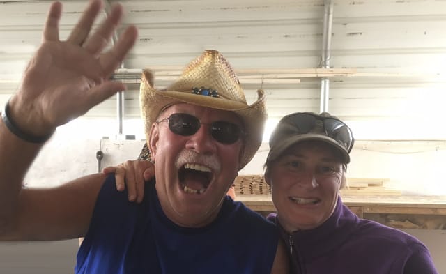 Two smiling guests waving at the camera