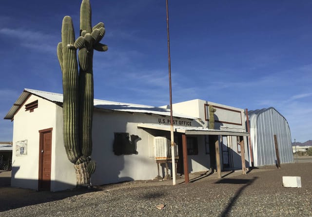 Quartzsite's U.S. Post Office with a tall saguaro beside it
