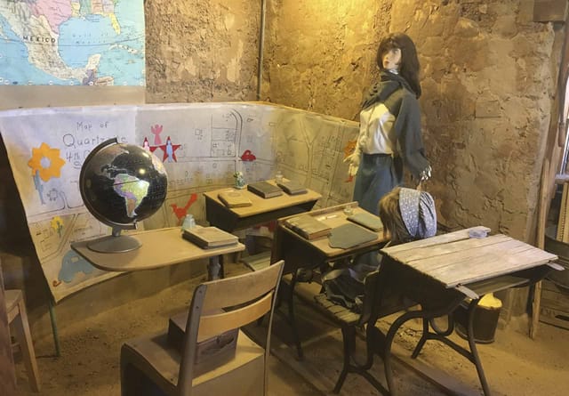 Old-time schoolroom display with wooden desks and a globe