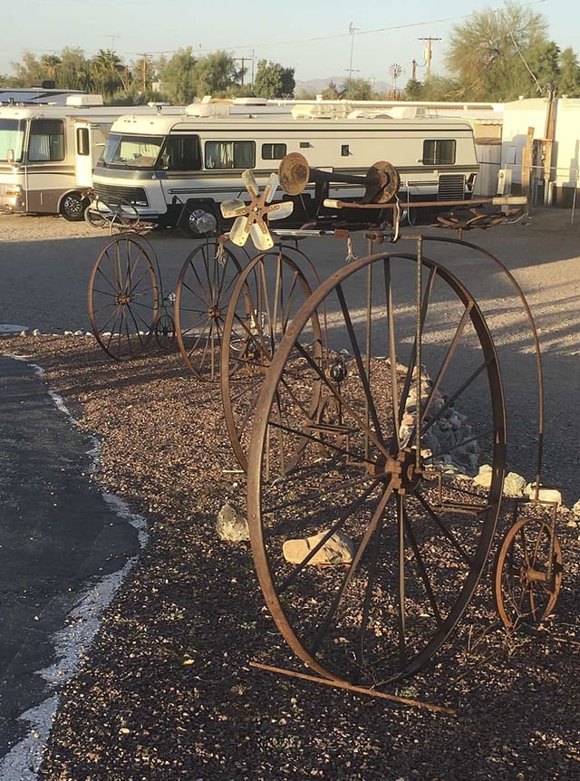Antique wagon wheels and high-wheel bicycle sculptures