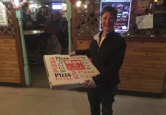 Guest holding a pizza box at Silly Al's Pizza